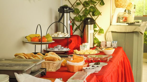 Una mesa de buffet con diversos alimentos y una cafetera.