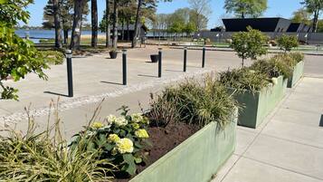 A landscaped area with planters, a pathway, and a building in the background.