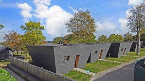 A modern building with a unique angular design, featuring multiple rooms with visible windows and doors. - SØGAARDEN - Hotel & SøCamp (Sunds)