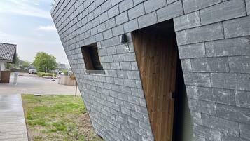 Un edificio moderno con techo inclinado y puerta de madera.
