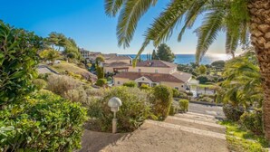 A coastal residential area with houses, a clear sky, and a view of the ocean. - Les Bastides (I3 049) by Interhome (Agay Village Cap Esterel)