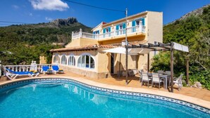 A two-story house with a swimming pool, outdoor seating, and a mountain backdrop. - Villa Mandana by Interhome (Dénia)