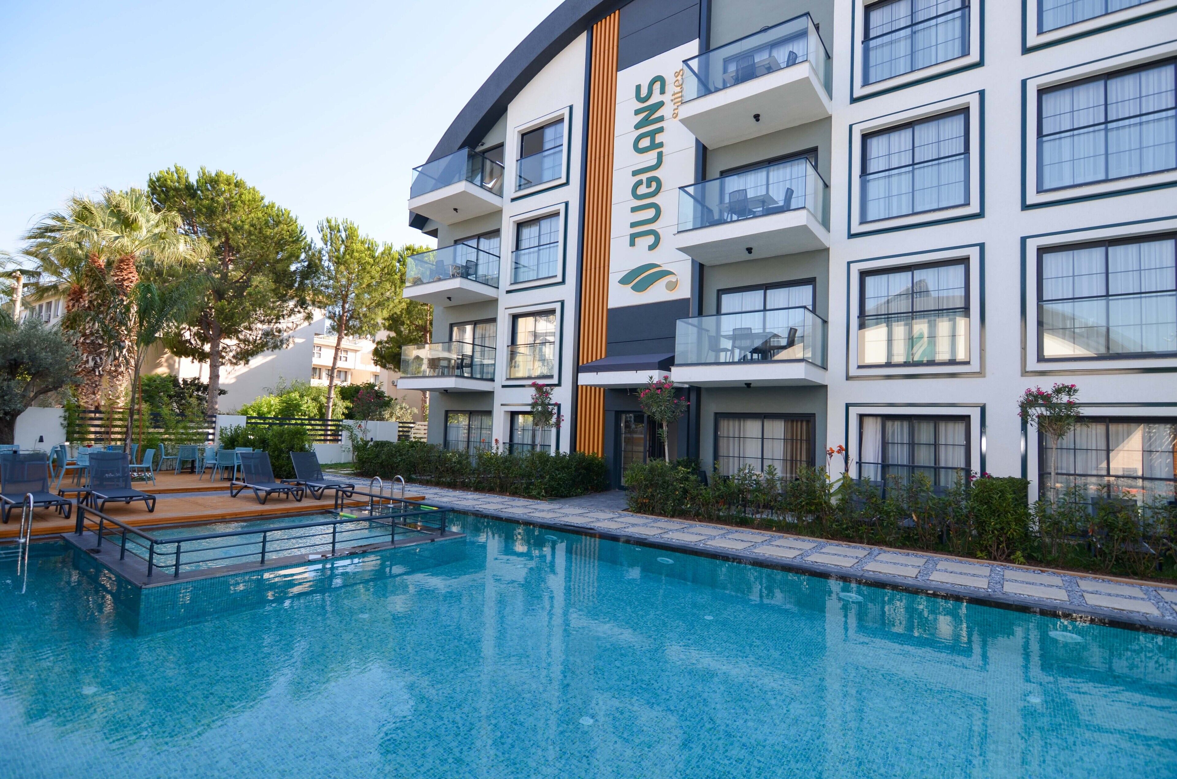 Un hôtel moderne doté d’une piscine, d’un espace extérieur aménagé et de balcons.