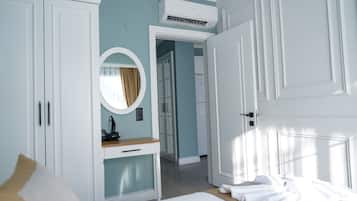 Un dormitorio con cama, mesita de noche, espejo y armario.