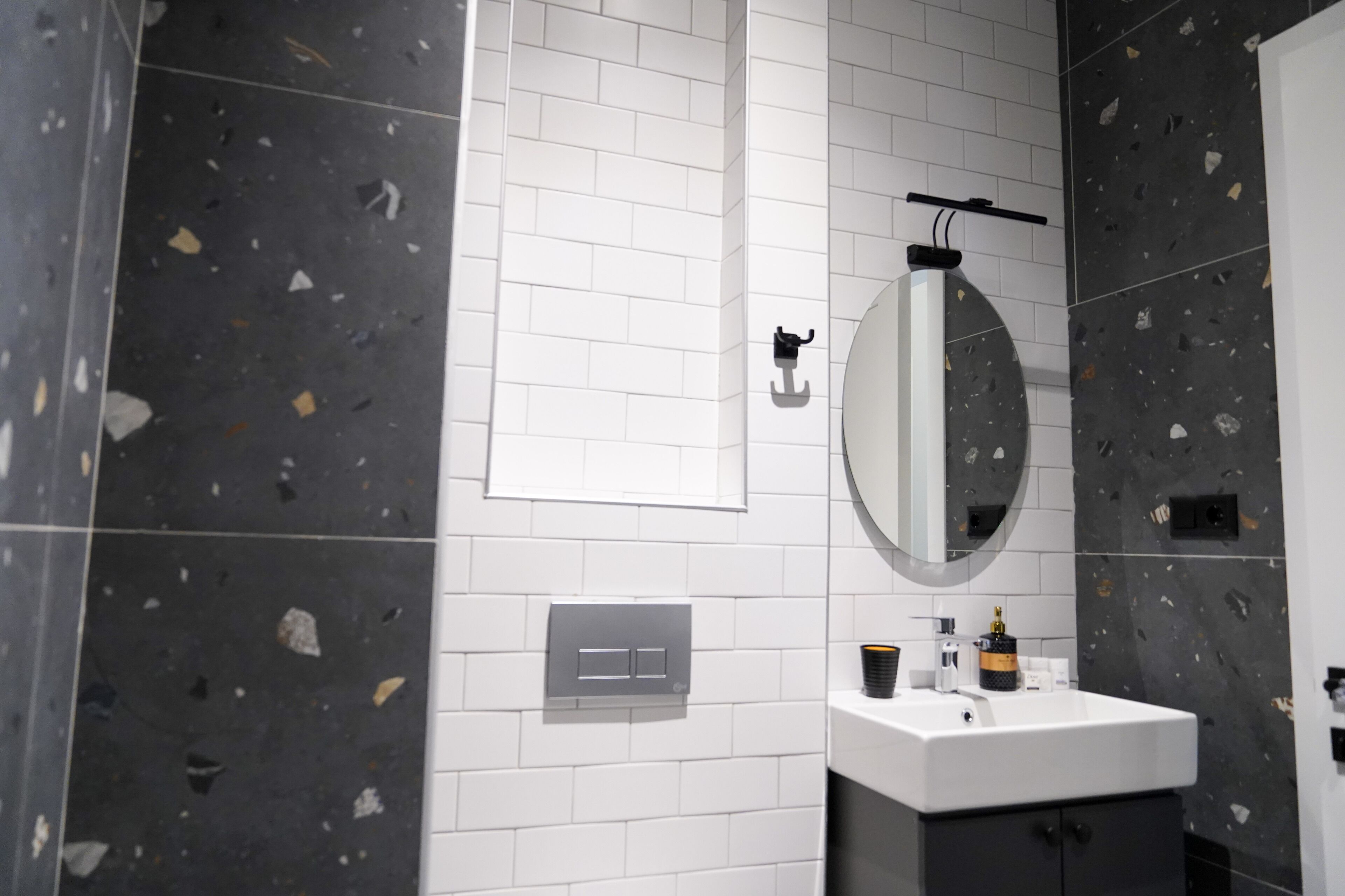 Un baño moderno con un lavabo blanco, un espejo y un toallero.