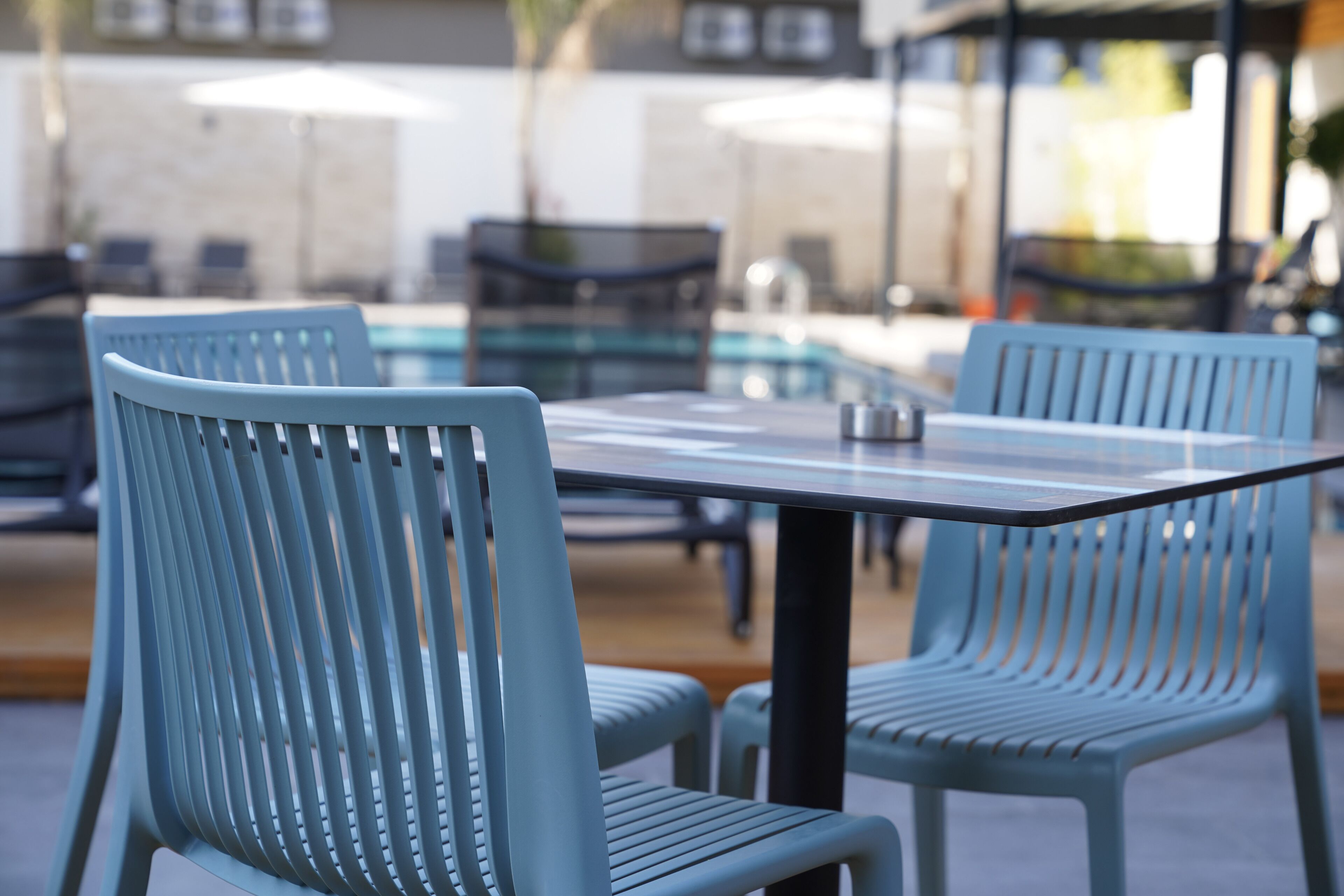 A poolside area with outdoor seating and a pool.