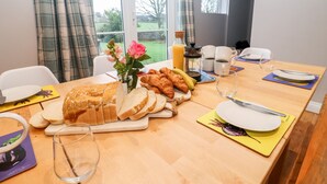 A breakfast table with croissants, bread, and a bottle of orange juice. - Ley Mill Farm (Westbury-on-Severn)