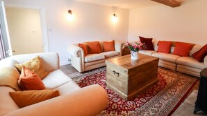 A living room with two sofas, a coffee table, and a patterned rug. - Ley Mill Farm (Westbury-on-Severn)