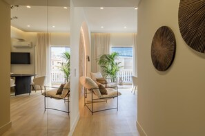 A modern living room with a sofa, a dining table, and a TV.