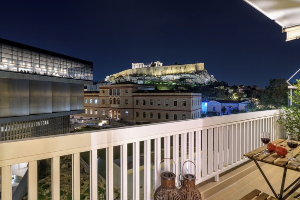 A balcony with a view of a historic building and a modern structure.