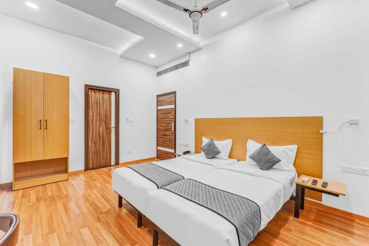 A modern bedroom with a large bed, wooden wardrobe, and a ceiling fan.