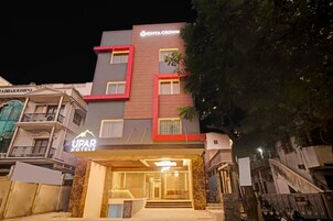 A hotel with a modern facade, featuring a prominent sign for 'UPAR HOTELS' and 'IDHYA CROWN' above the entrance.