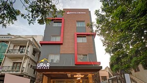 Un hôtel à la façade moderne, avec une enseigne bien visible indiquant « UPAR HOTELS » et « IDHYA CROWN ».