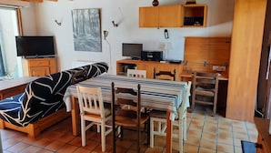 A cozy room with a bed, a dining table with chairs, a TV, and a computer setup. - Family Villa with Terrace, Near Beach and Shops in Seignosse (Seignosse)