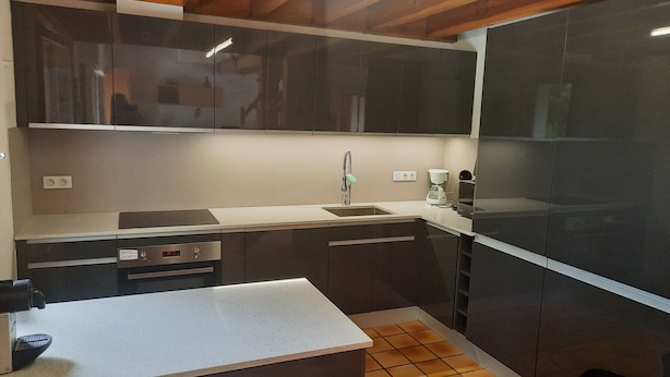 A modern kitchen with dark cabinets, a white countertop, a sink, a coffee maker, and a tiled backsplash. - Family Villa with Terrace, Near Beach and Shops in Seignosse (Seignosse)