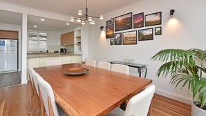 A modern kitchen with white cabinets, a built-in oven, and a coffee machine.