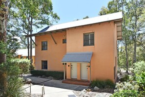 A single-story building with a flat roof, a small porch, and a door with a window.