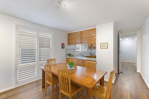 Enjoy meals in this cozy dining area with a table and chairs, adjacent to a fully equipped kitchen.