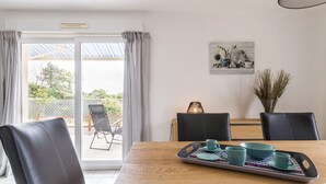 A dining area with a wooden table, black chairs, and a tray with cups and bowls. - 3-bedroom house, near beach, pets allowed, parking (Gouville-sur-Mer)