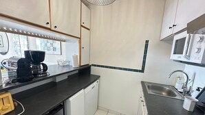 Une cuisine moderne équipée d’une machine à café, d’un four à micro-ondes et d’un évier.