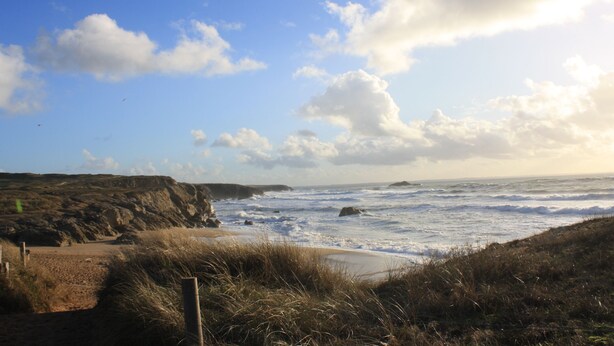 A coastal landscape with a sandy beach, grassy dunes, and a rocky cliff. - Ty Laouen, Peaceful fisherman's cottage, close to the beach, WIFI (Quiberon)