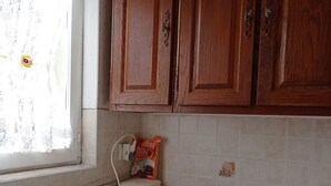 A kitchen with wooden cabinets, a microwave, a coffee maker, and a sink. - 1 Bedroom Apartment in Carnoux-en-Provence (Carnoux-en-Provence)