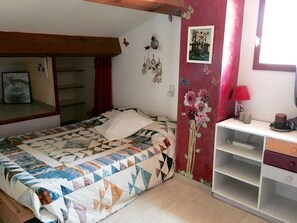Une chambre à coucher comprenant un lit, une commode, un miroir et un mur décoré.