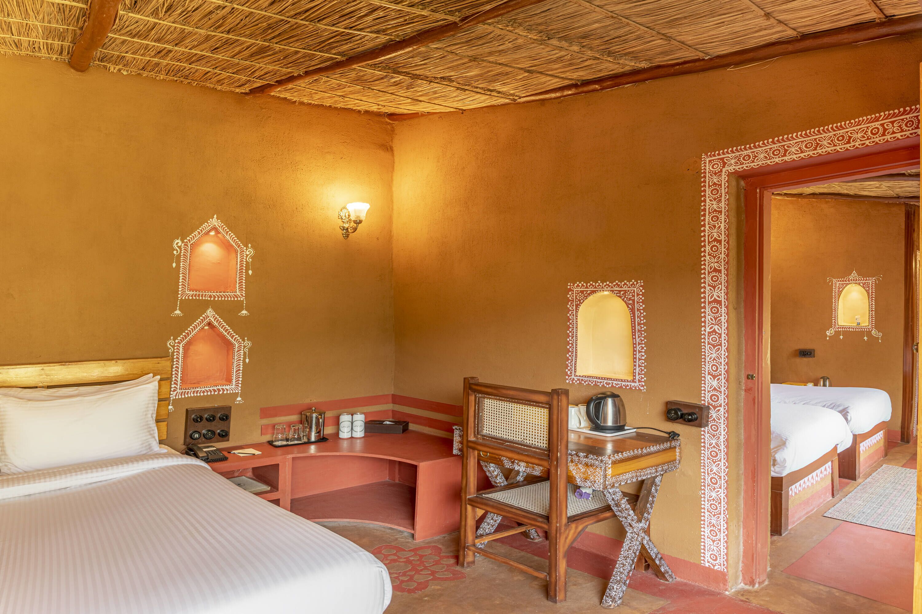 A hotel room with a bed, a desk, a chair, and a bathroom with a mirror.