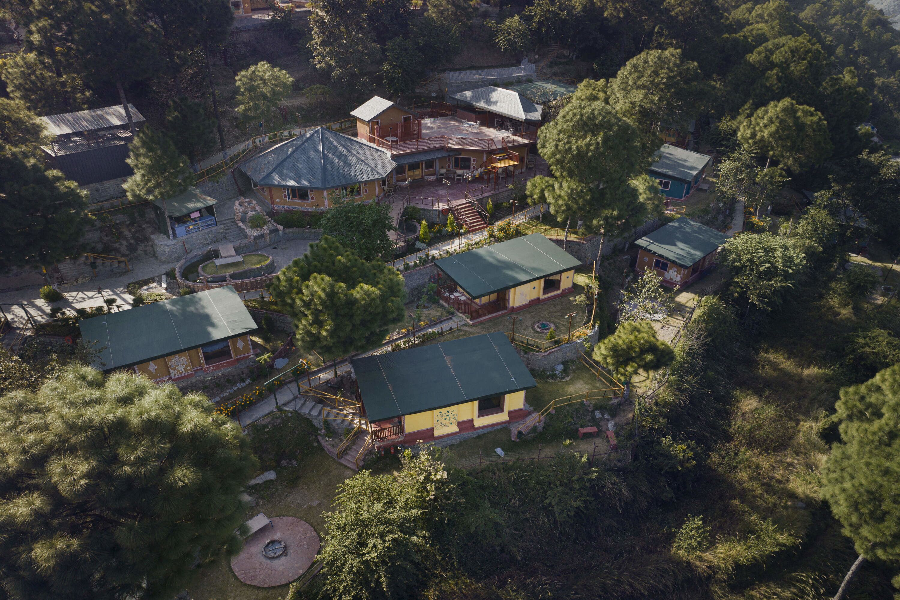 An aerial view of a resort with multiple buildings, a central courtyard, and surrounding greenery.