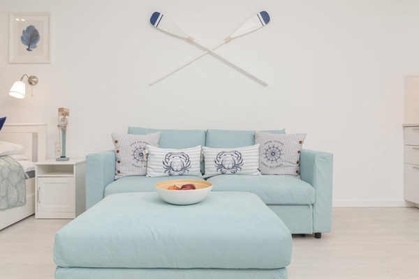 Modern and bright studio with a sofa bed and TV.