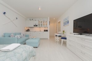 Un appartement moderne comprenant un coin cuisine, un espace repas, un canapé et un lit.