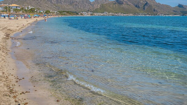 A beach with clear water, a sandy shore, and mountains in the background. - Holiday Apartment "Veleta ll" close to Beach with Sea View, Shared Pool & Wi-Fi (Pollença)