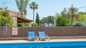 A swimming pool with lounge chairs, a sign reading 'LA VELETA,' and a palm tree in the background. - Holiday Apartment "Veleta ll" close to Beach with Sea View, Shared Pool & Wi-Fi (Pollença)