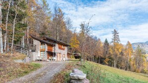 A stone cabin with a wooden exterior, a stone staircase, and a dirt path leading to the entrance. - Chalet 'Baita Al Rossat' with Mountain Views, Garden and Wi-Fi (Sant'Orsola)