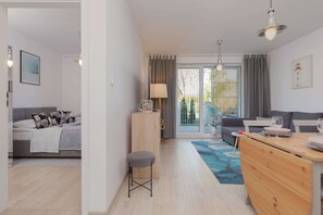 Una sala moderna con un sofá, una mesa de comedor y una zona de cocina.