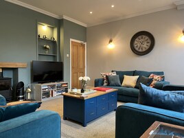 A living room with a television, bookshelves, a coffee table, and a sofa.