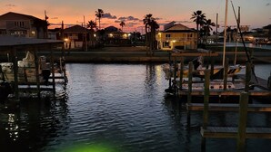 A marina at dusk with docked boats and waterfront houses. - Bikini Bottom: Close to pool, dining, beach, pets (Galveston)