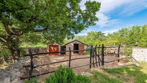 A rustic wooden fence, a stone wall, and a small wooden building with a sloped roof. - Villa Stone House Magarac (Starigrad)
