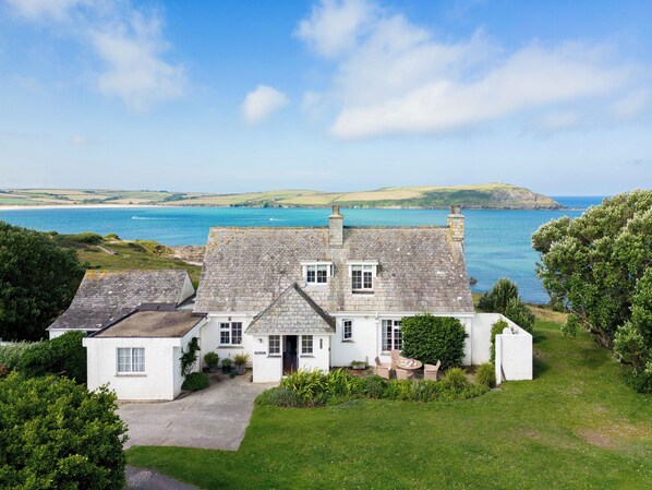 A coastal house with a stone roof, a front porch, and a view of the sea. - Thalassa (Wadebridge)