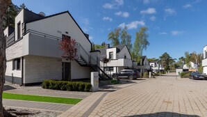 A modern residential building with a staircase, a garage, and a paved driveway.