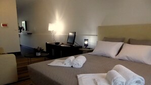 Une chambre d’hôtel équipée d’un lit, d’un bureau, d’une chaise, d’une lampe et d’un téléviseur.