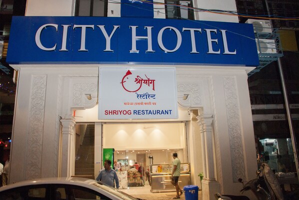 The exterior of the City Hotel with a sign for Shriyog Restaurant.