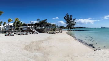 Privat strand, vit sandstrand, solstolar och parasoller