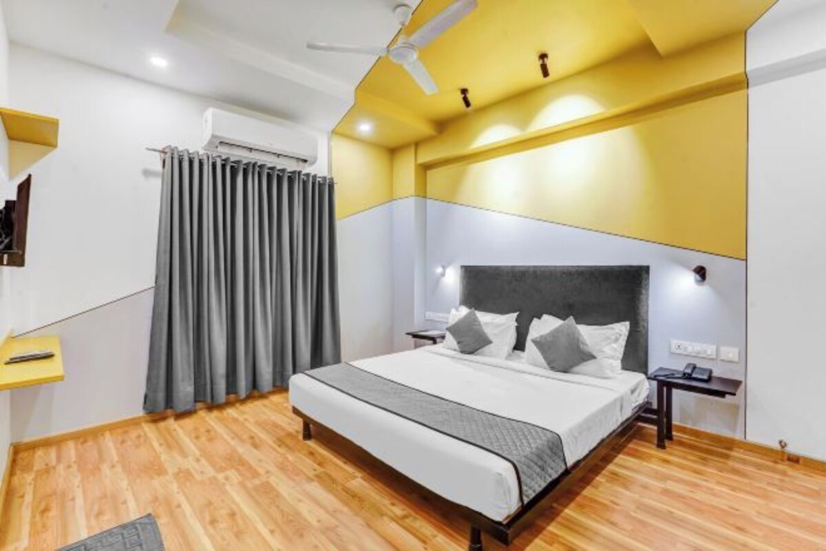 Une chambre moderne équipée d’un lit, de tables de chevet, d’un ventilateur de plafond et d’un appareil de climatisation.
