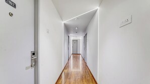 A hallway with a wooden floor, white walls, and a door labeled "101".