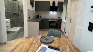 A modern kitchen with dark cabinets, a built-in oven, and a microwave. - Street Living Hotel (Vienna)