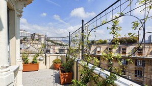 A rooftop terrace with potted plants, a metal railing, and a view of the cityscape. - The Liberty Rooftop Terrace by Wonderful Italy (Genova)