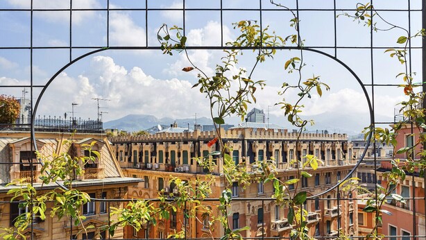 A view through a metal fence with buildings in the background. - The Liberty Rooftop Terrace by Wonderful Italy (Genova)