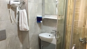 A modern bathroom with a toilet, sink, and shower. - Esas Pansiyon (Gemlik)