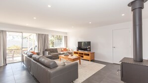 A modern living room with a sofa, TV, and a fireplace.